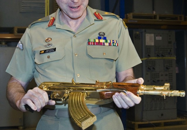 This handout photo released by the Australian War Memorial shows Deputy Chief of Army, Major General John Cantwell inspecting a gold plated Tabuk assault rifle from the regime of Saddam Hussein, in Canberra, 18 June 2007. The rifle was found in Kirkuk, Iraq, and presented to Australian forces.  AFP PHOTO/HO/AUSTRALIAN WAR MEMORIAL  = RESTRICTED TO EDITORIAL USE =